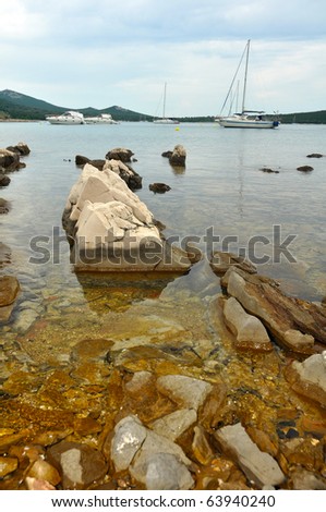 white yachts in a rocky bay, vertical photo
