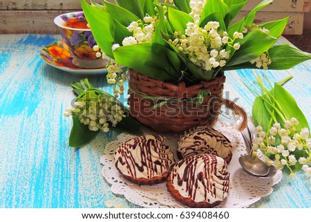 Biscuits with cream and a bouquet of lilies of the valley