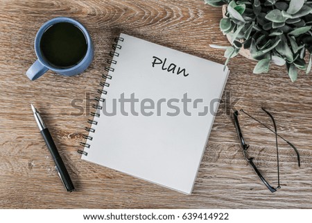 Goals Text on Notebook on working table with coffee cup, pen and glasses