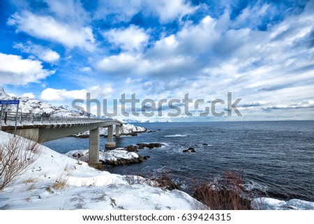 Norway. Lofoten. Beautiful landscape. The bridge is on the water in the background of  mountains and blue sky.