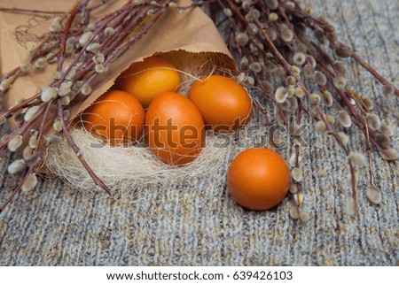 Easter colored eggs in a paper bag with branches of pussy willow, spring mood