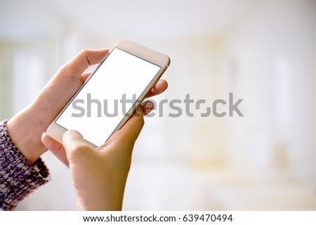 Woman holding smart phone with blurred backgroung.