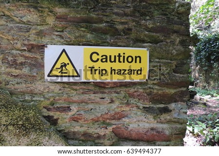 Caution Trip hazard - a sign on the wall of a derelict Victorian tea house, on the coastal path near Portwrinkle in southeast Cornwall