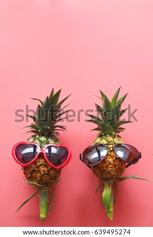 A pineapple with red sunglasses and headphone on pink background.