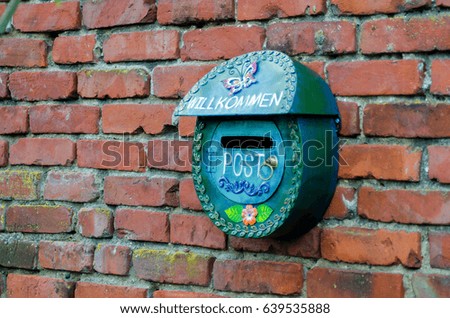 Green Postal Box against red Brick wall. Old vintage metallic mailbox or post box . An old mail box.