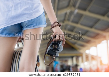 Photographer standing and holding camera at train station