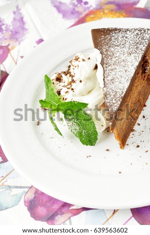 Sweet chocolate cake with ice cream decorated with mint leaves. Dessert with chocolate and cream on a white porcelain plate. Chocolate dessert in a restaurant menu.