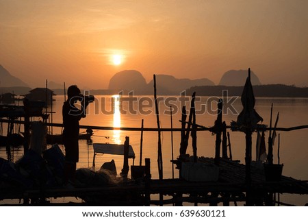 Beautiful sunrise with silhouettes photographer at Ban Sam Chong Tai Village, Phang Nga,thailand