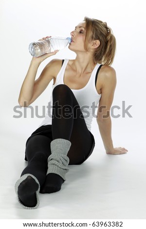Pretty blond lady making sport and driking water isolated in a white background