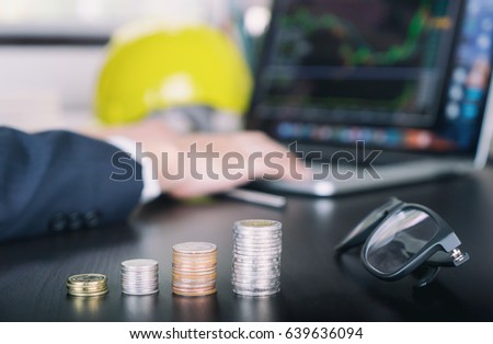 Engineer counting income money from stock market with his pen