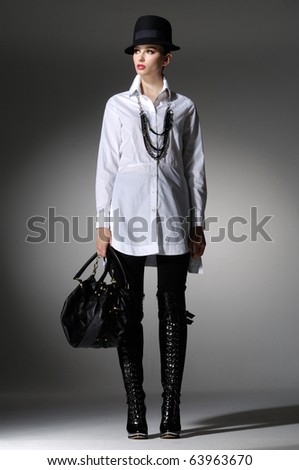 High fashion model with bag posing in the studio