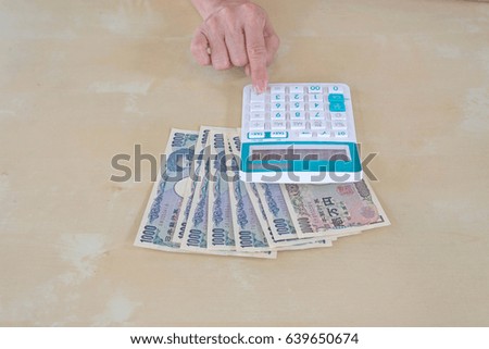 hand woman with Japanese currency yen bank notes and  using calculator.
