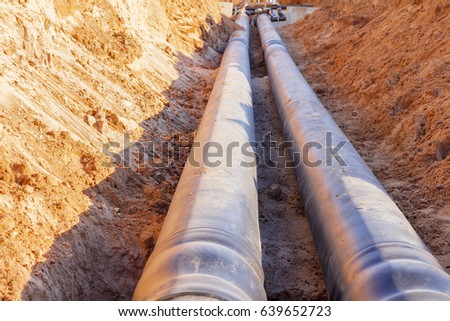 The process of installation of the distribution unit heating network. Frame for connecting pipes in the trench of sand. Royalty-Free Stock Photo #639652723
