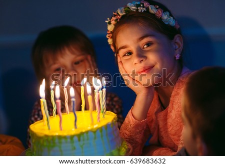 Children's birthday. Children near a birthday cake with candles.