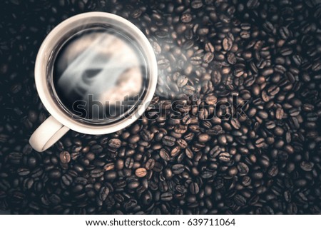 Hot coffee is in a white cup Placed on the ground coffee beans.