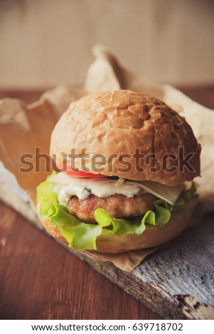 Close-up photo of home made hamburger with beef, onion, tomato, lettuce, cheese and spices.