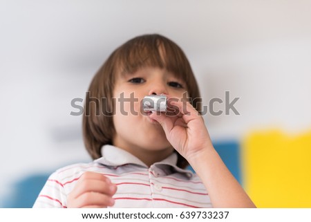 young happy boy having fun and blowing a noisemaker