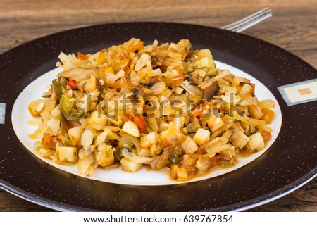 Fried cabbage with onions and paprika on plate. Studio Photo