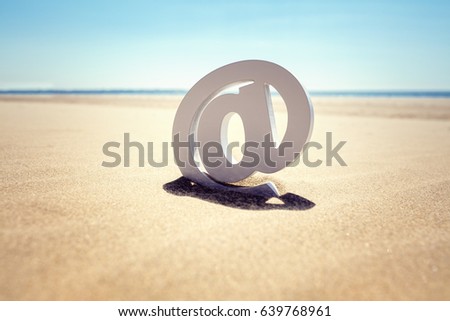 Email at symbol in the sand at the beach