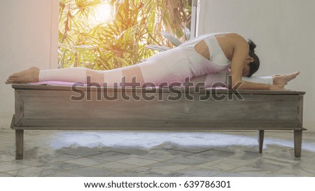 Young woman practicing yoga with indoor home interior background,