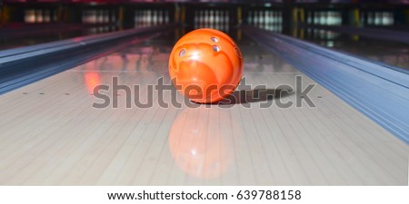 Orange bowling ball on the track. Active leisure. Sport game.