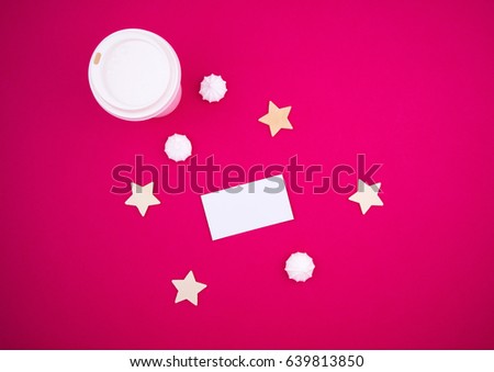 Business card mock up on a pink red background table, star and coffee. View from above. Flat lay