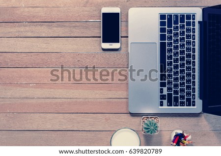 Office stuff and it gadgets display on top view business desk with copy space at text of picture. Creative table, modern project. Business mockup at empty laptop smartphone device on wood background.