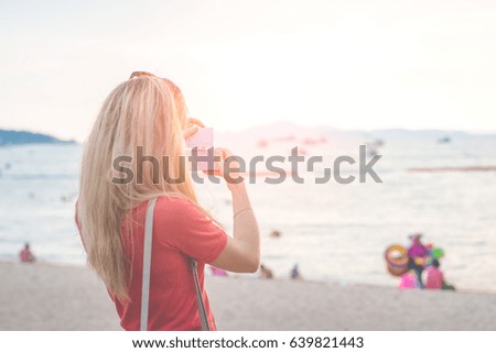 Woman taking a photo at the beach