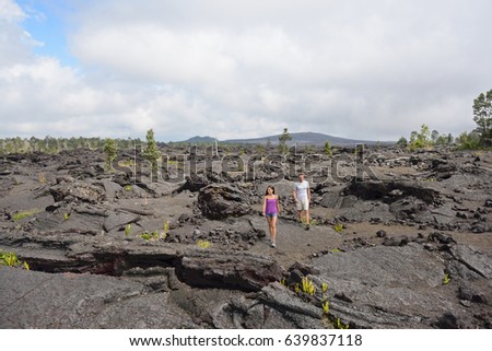 Hawaii destination travelers couple hiking in volcanic rocks on Kilauea volcano in Big island of Hawaii