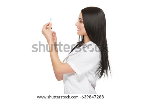 A portrait of a young female doctor smiling with a syringe in her hand. Portrait of a beautiful woman doctor. Isolated over white background. Young woman doctor holding syringe on white background