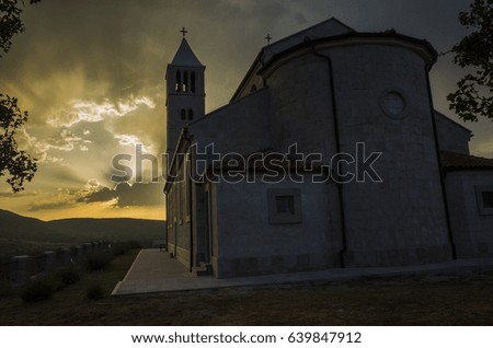 Church in Cetina Croatia. Beautiful sunset with sunrays in sky and clouds. Magical evening.