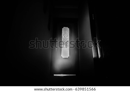 Silhouette of an unknown shadow figure with hands on a door through a closed glass door. Horror concept