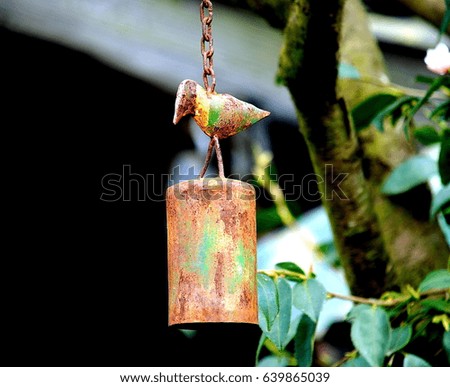 Rusty metal bell with bird shape