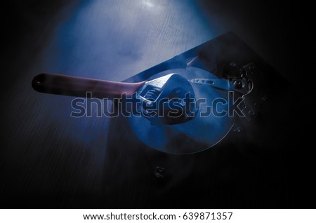 Adjustable wrench turn off a hard disk. On a dark background. Computer repair concept. Useful as background or poster