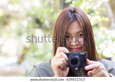 Lifestyle of Beautiful Long Hair Woman is Holding Digital Camera for Take a Photo in The Garden. Asian Female Model Portrait Close Up Concept. Copy Space for Text.