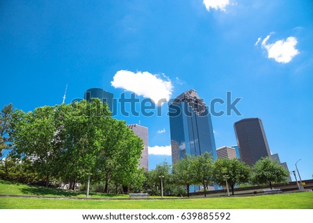 Downtown Houston during daytime with cloud blue sky. Green lawn, trees and modern skylines. The most populous city in Texas and the fourth-most in United States. Travel and architecture background.