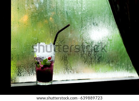 Cool Soft Drink Mix Berry Soda on Raining Background at the Window