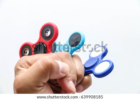 Colorful Fidget finger spinner stress, anxiety relief toy. Male hand holding popular finger spinning toy. 
