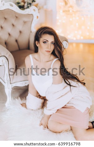 Portrait of beautiful young brunette woman with makeup in fashion clothes