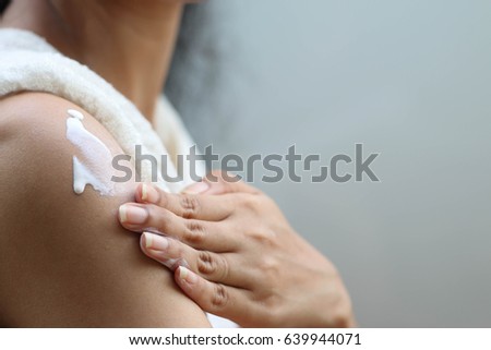 Hand and arm of lady that doing apply whitening lotion on tantalum of her skin