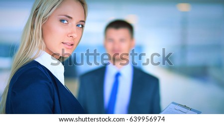 Businesswoman standing in office , holding documents in hand