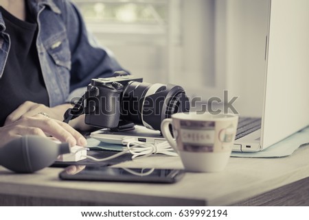 Focus camera, Professional female photographers are working at a home office desk with vintage color tone
