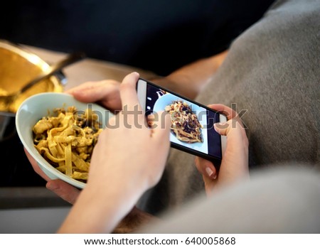 Couple taking photo of spaghetti with smart phone
