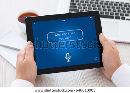 tablet with app personal assistant on screen in male hands over table in office Royalty-Free Stock Photo #640010005