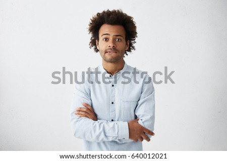 Scared young Afro American man in casual shirt keeping arms folded, biting lips, feeling nervous and impatient while waiting for his wife giving life for their first child. Human emotions and feelings Royalty-Free Stock Photo #640012021