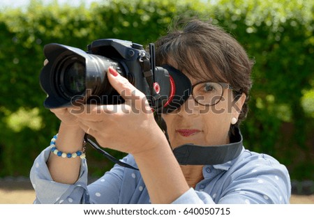 A mature woman using a camera dslr