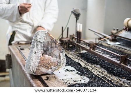 Industrial tinning of wire. A large piece of tin solder lies on the edge of the tin bath.