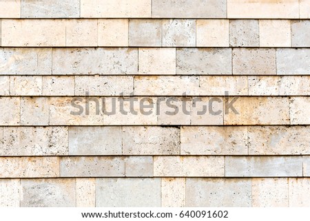 Surface of the wall of beige and gray stone tiles, texture