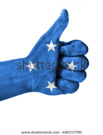Hand making thumbs up sign.Micronesia painted with flag as symbol of thumbs like,up,okay. Isolated on white background.