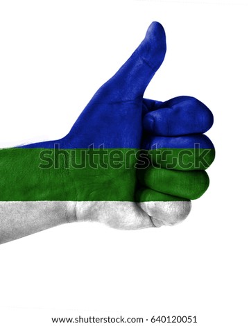 Hand making thumbs up sign.Komi painted with flag as symbol of thumbs like,up,okay. Isolated on white background.